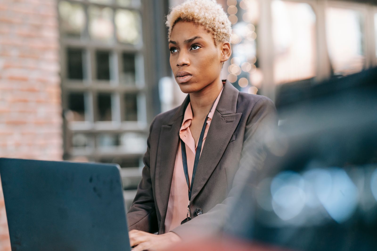 A Black businesswoman working on her laptop, focused on managing her business systems